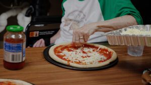 A woman at a skilled nursing facility makes a pizza