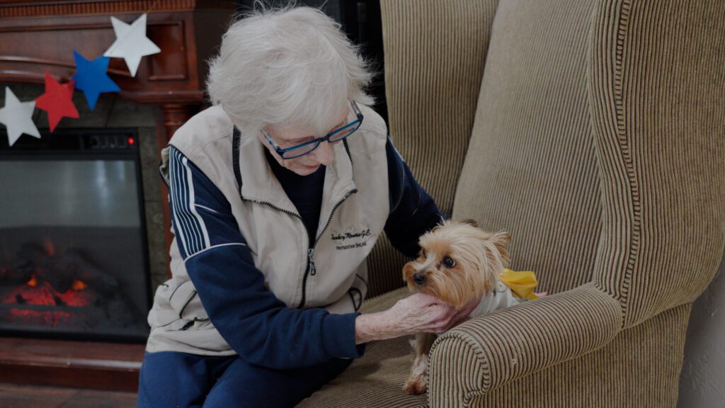 A woman pets a dog at a respite care facility