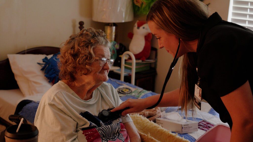 A woman in long term care is being assisted by a nurse
